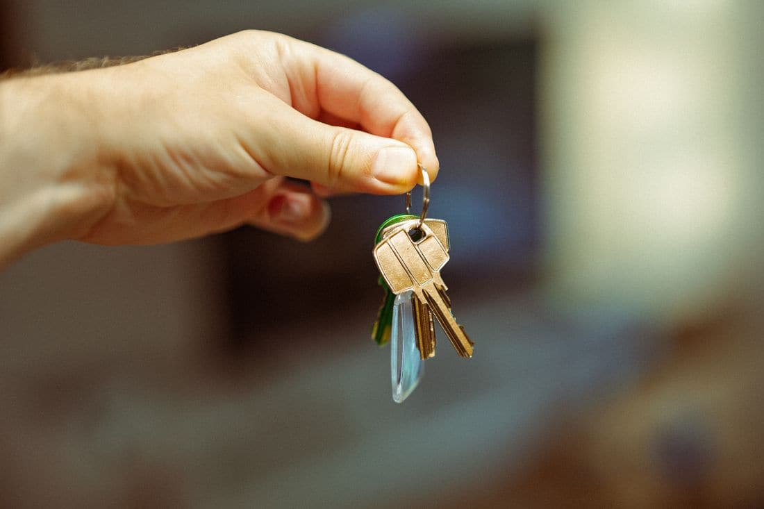 A hand holding up a ring of keys