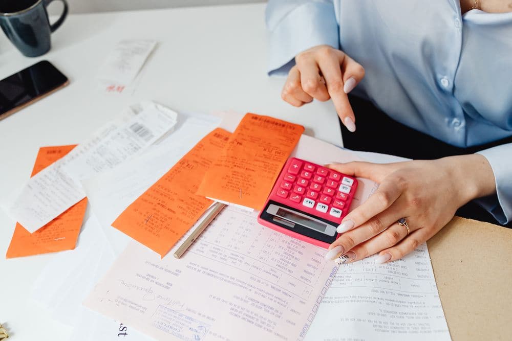 Receipts and a calculator on a desk while expenses are added up
