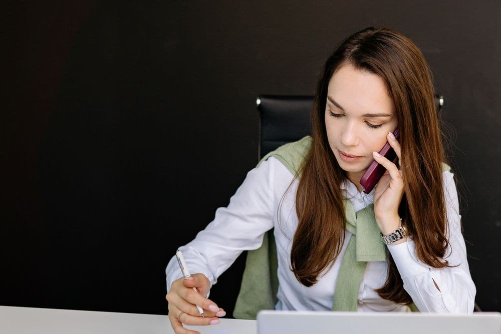 A manager on a phone call while taking notes
