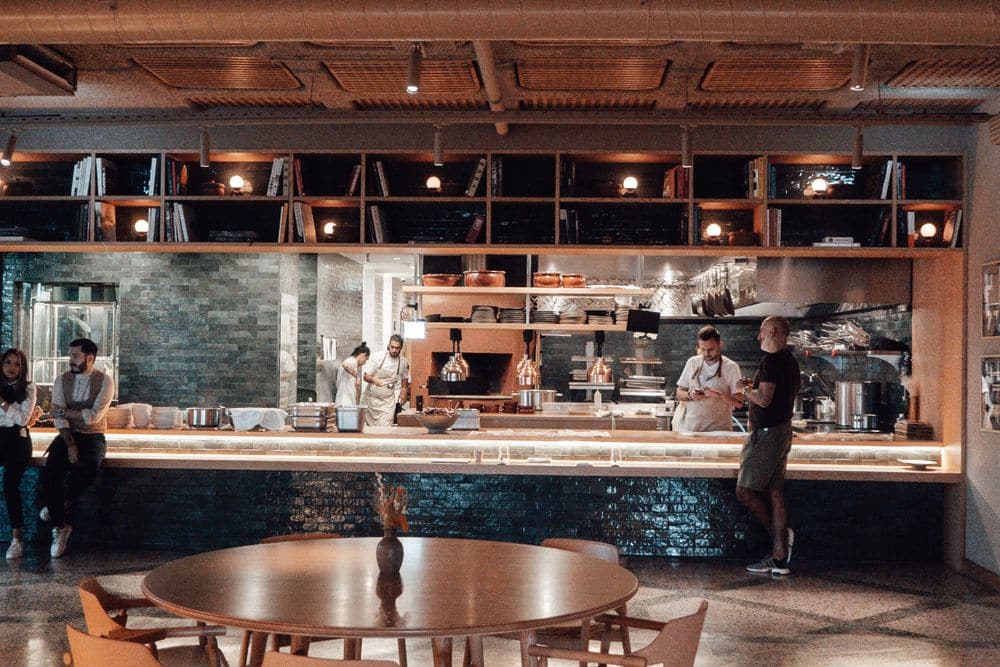 Staff at the open kitchen of a busy restaurant