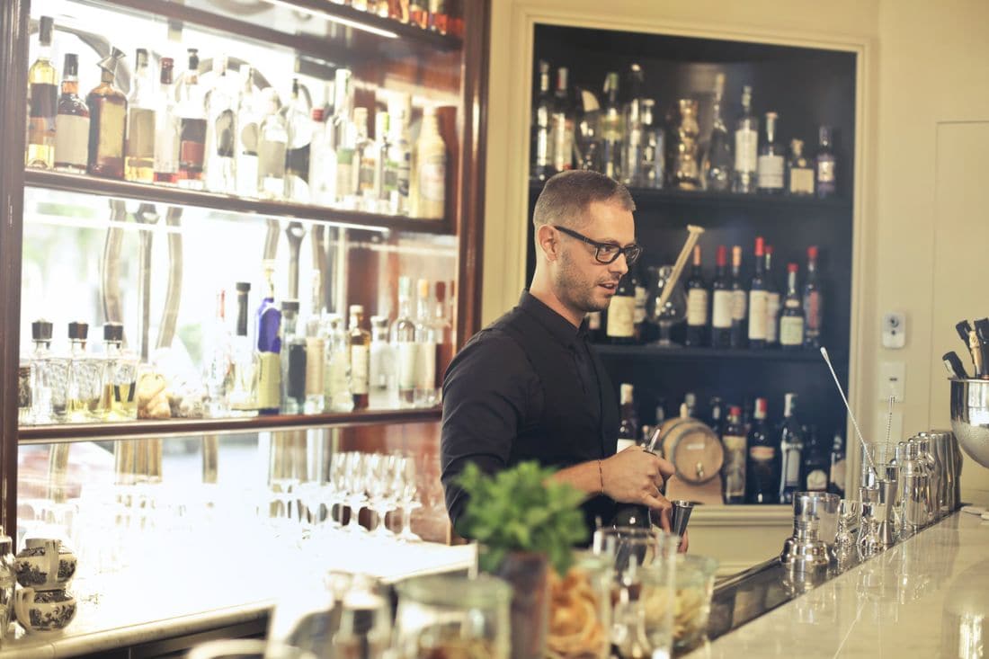 A bartender making cocktails behind the bar