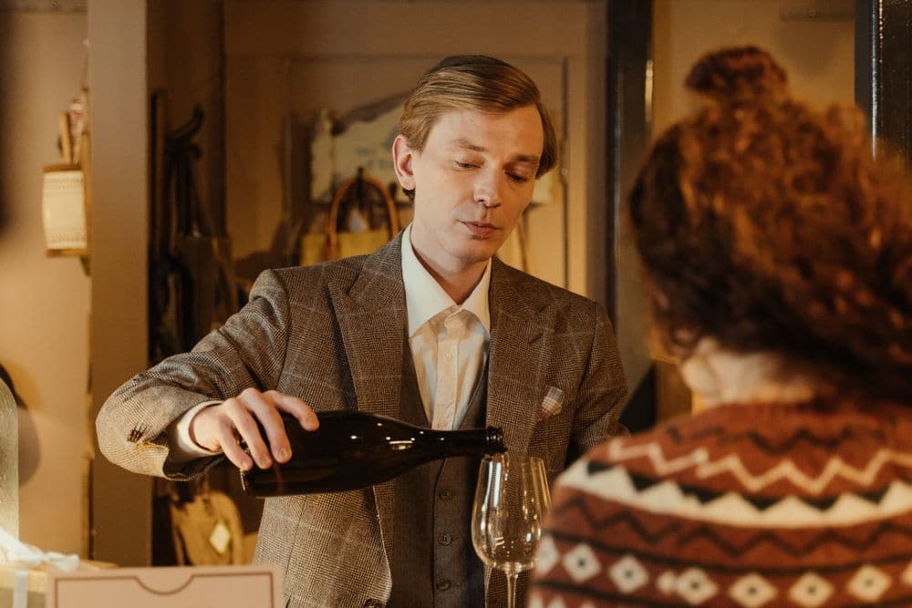 A staff member pouring a tasting of wine for a customer