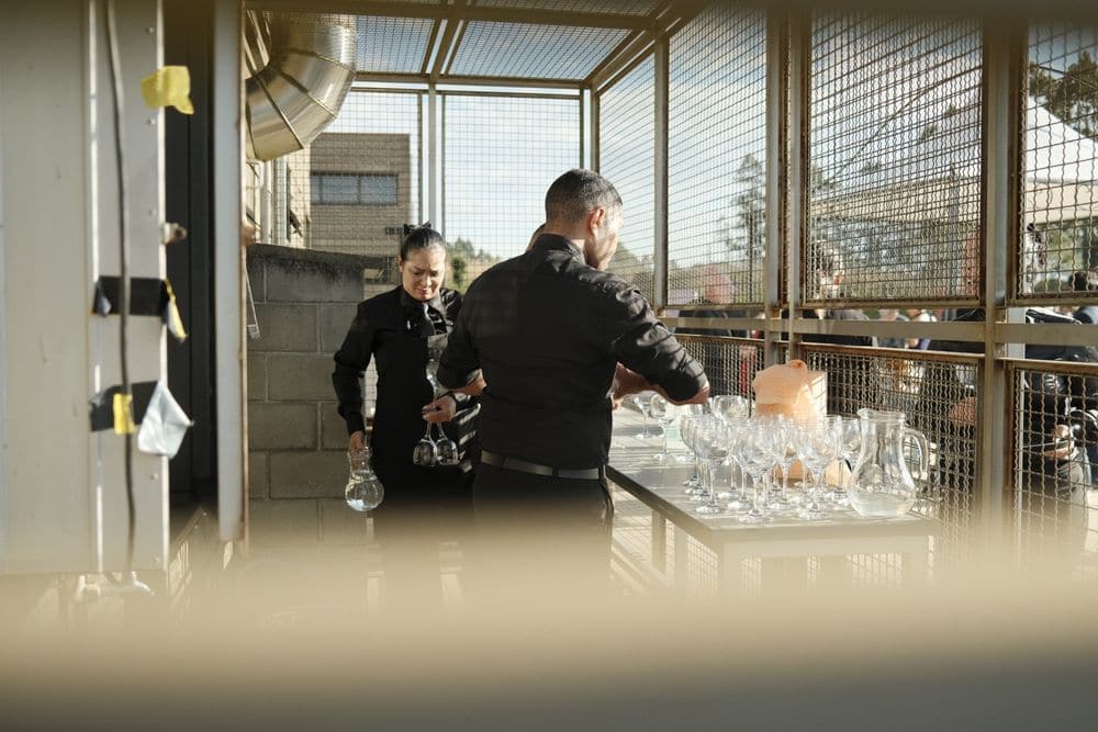 Catering staff setting out glassware for an outdoor event