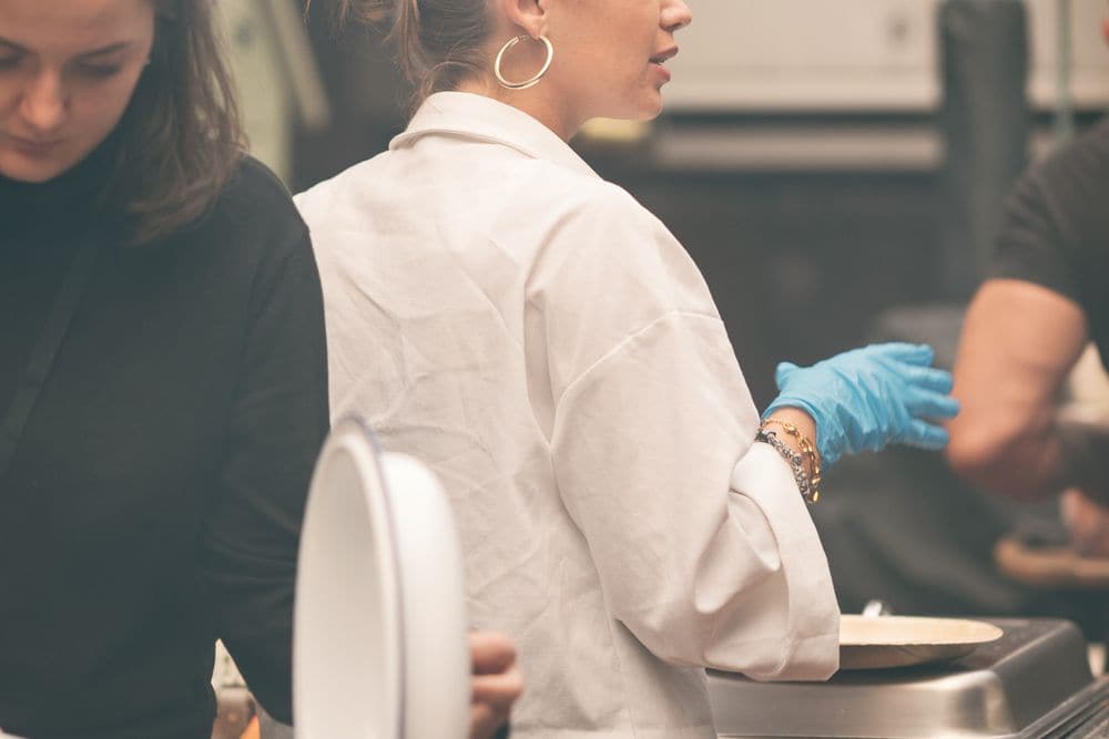 Chefs preparing plates in a kitchen for an event