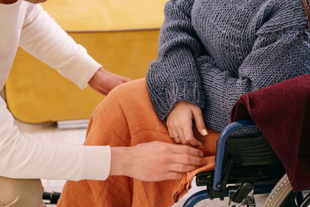 A support worker helping a woman in a wheelchair
