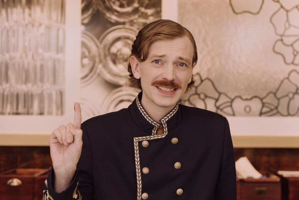 A hotel porter in uniform at the front desk