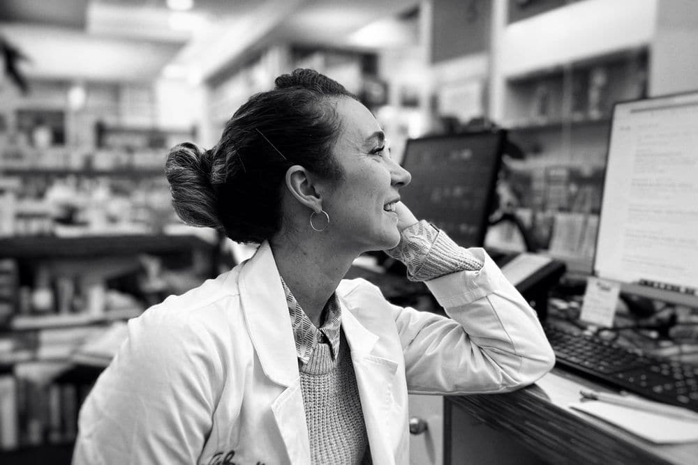 A pharmacist smiling at the dispensary counter