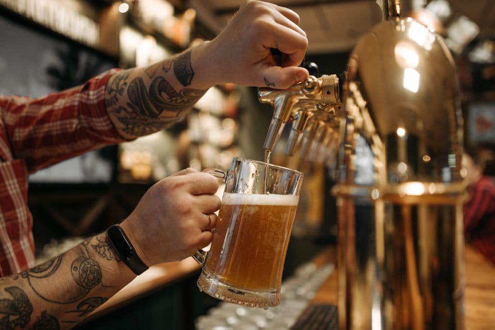 A bartender pouring a beer from the tap